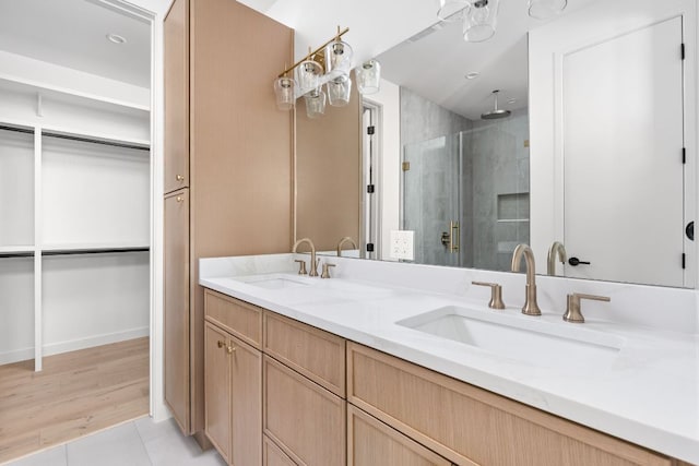 2917 Lyons Rd Unit 1, Austin, TX 78702 - bathroom with a stall shower, double vanity, a walk in closet, and tile patterned floors