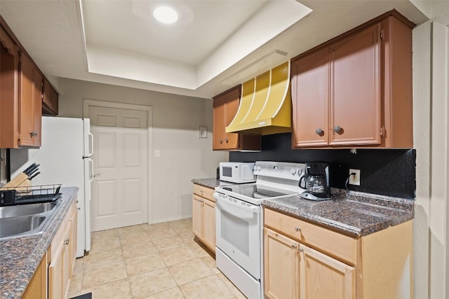2503 Parker Ln Unit A & B, Austin, TX 78741 - kitchen with white appliances, custom range hood, dark countertops, a tray ceiling, and light tile patterned floors