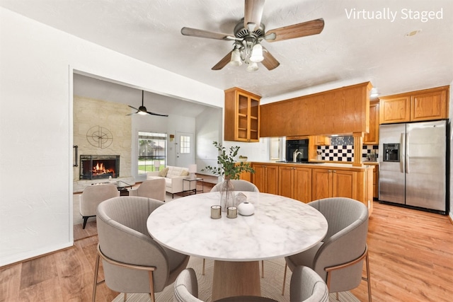 8511 Slant Oak Dr, Austin, TX 78729 - dining room with a ceiling fan, light wood finished floors, and a fireplace