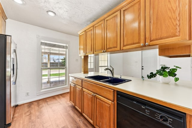 8511 Slant Oak Dr, Austin, TX 78729 - kitchen with dishwasher, stainless steel refrigerator with ice dispenser, light wood-type flooring, light countertops, and brown cabinetry