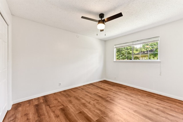 8511 Slant Oak Dr, Austin, TX 78729 - unfurnished bedroom featuring wood finished floors, a closet, a textured ceiling, and ceiling fan