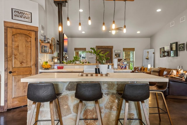 201 N Oak Vista Dr, Burnet, TX 78611 - kitchen with concrete flooring, open floor plan, recessed lighting, light countertops, and a kitchen breakfast bar