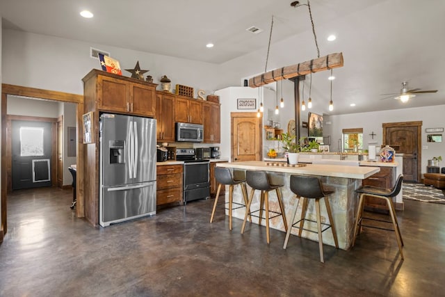 201 N Oak Vista Dr, Burnet, TX 78611 - kitchen featuring finished concrete flooring, appliances with stainless steel finishes, a kitchen breakfast bar, light countertops, and brown cabinetry