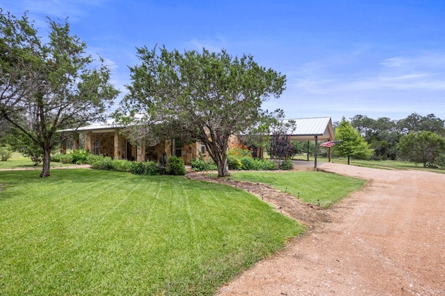 201 N Oak Vista Dr, Burnet, TX 78611 - obstructed view of property with a front yard, dirt driveway, stone siding, a metal roof, and an attached carport