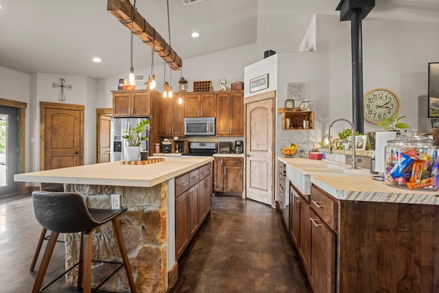 201 N Oak Vista Dr, Burnet, TX 78611 - kitchen featuring finished concrete floors, appliances with stainless steel finishes, light countertops, a breakfast bar area, and recessed lighting