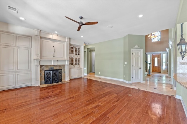 15208 Sunningdale St, Austin, TX 78717 - unfurnished living room with a chandelier, a ceiling fan, light wood finished floors, a tile fireplace, and recessed lighting
