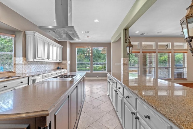 15208 Sunningdale St, Austin, TX 78717 - kitchen featuring island range hood, white cabinets, tasteful backsplash, light tile patterned floors, and light stone countertops