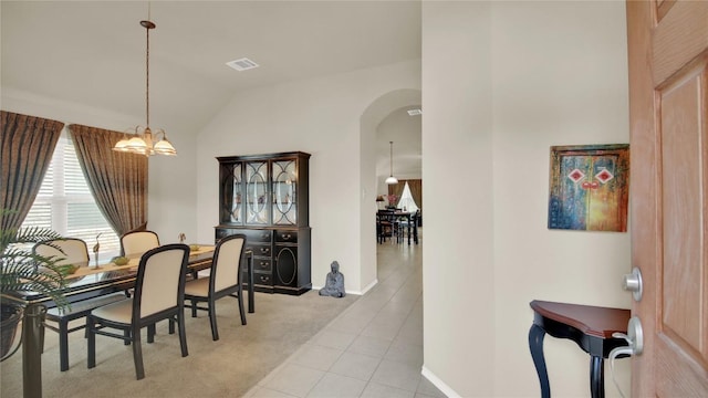11017 Casitas Dr, Austin, TX 78717 - dining space featuring arched walkways, vaulted ceiling, carpet flooring, tile patterned floors, and a chandelier