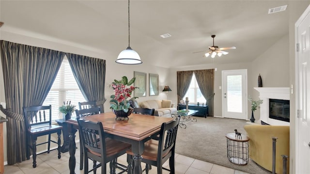 11017 Casitas Dr, Austin, TX 78717 - dining room featuring a ceiling fan, light tile patterned floors, a glass covered fireplace, and light carpet