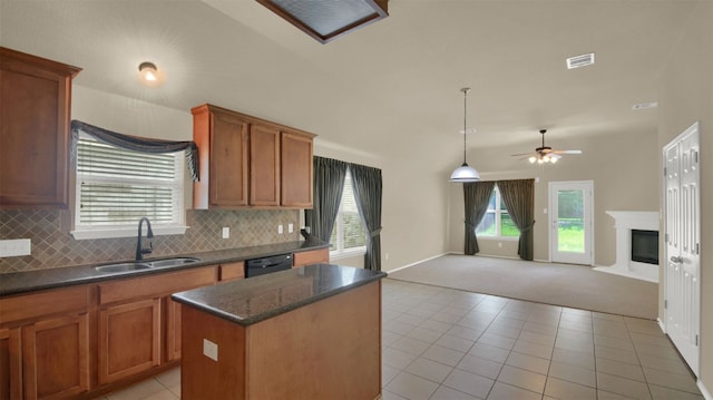 11017 Casitas Dr, Austin, TX 78717 - kitchen with light carpet, a kitchen island, a ceiling fan, tasteful backsplash, and brown cabinets