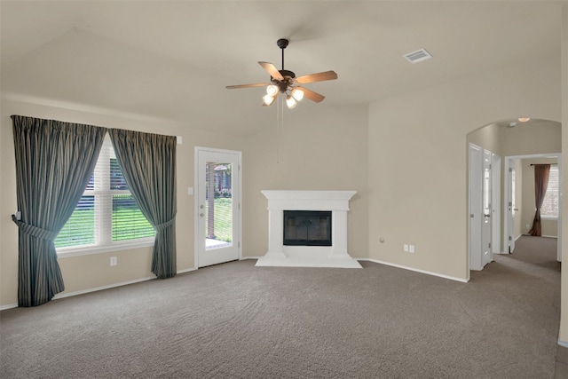 11017 Casitas Dr, Austin, TX 78717 - unfurnished living room with a ceiling fan, arched walkways, carpet, lofted ceiling, and a glass covered fireplace