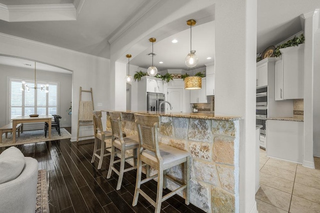 100 Eagle Landing Dr, Belton, TX 76513 - kitchen with crown molding, light stone countertops, decorative backsplash, white cabinets, and stainless steel fridge with ice dispenser