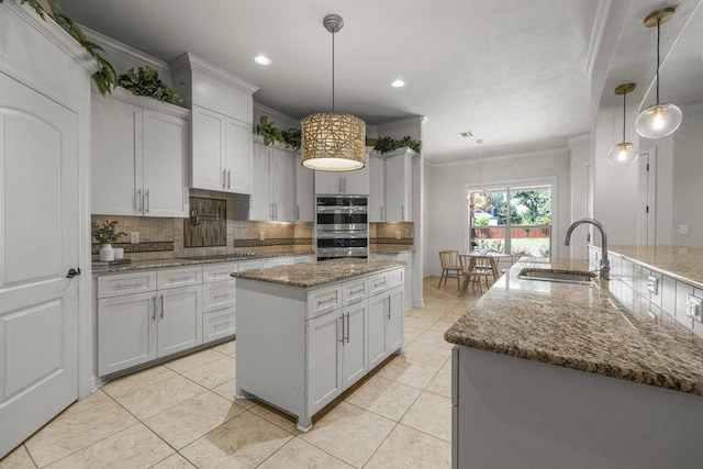 100 Eagle Landing Dr, Belton, TX 76513 - kitchen featuring a center island, backsplash, ornamental molding, stainless steel double oven, and white cabinets