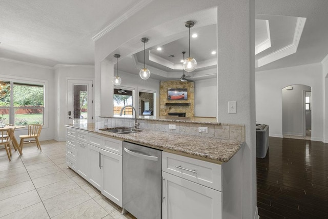 100 Eagle Landing Dr, Belton, TX 76513 - kitchen featuring dishwasher, a tray ceiling, arched walkways, ornamental molding, and light stone countertops