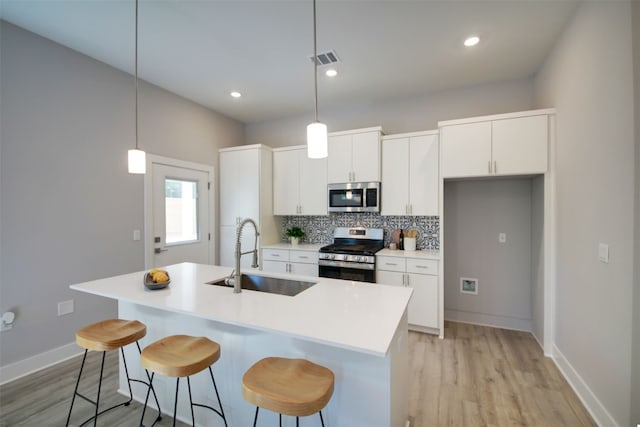 6111 Carnation Ter Unit 1, Austin, TX 78741 - kitchen featuring stainless steel appliances, light wood finished floors, tasteful backsplash, a breakfast bar, and recessed lighting