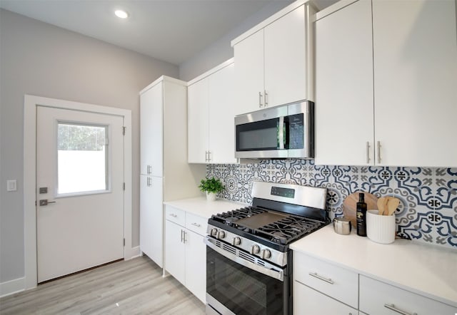 6111 Carnation Ter Unit 1, Austin, TX 78741 - kitchen featuring appliances with stainless steel finishes, tasteful backsplash, light wood finished floors, light countertops, and recessed lighting
