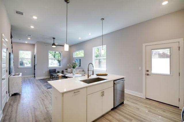6111 Carnation Ter Unit 1, Austin, TX 78741 - kitchen featuring light wood-type flooring, recessed lighting, a center island with sink, stainless steel dishwasher, and light countertops