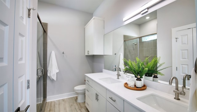 6111 Carnation Ter Unit 1, Austin, TX 78741 - bathroom featuring double vanity, a stall shower, and wood finished floors
