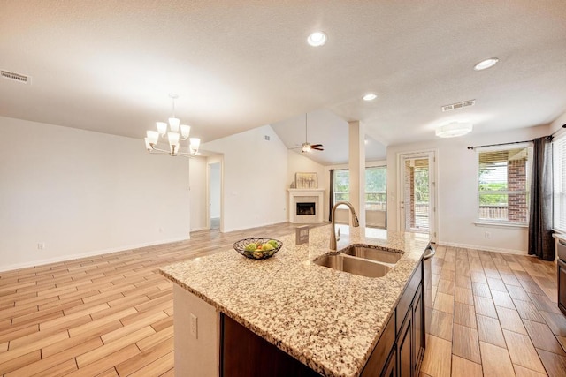 2953 Diego Dr, Round Rock, TX 78665 - kitchen with wood tiled floors, open floor plan, a fireplace, plenty of natural light, and recessed lighting