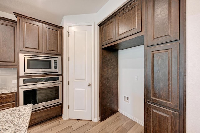 2953 Diego Dr, Round Rock, TX 78665 - kitchen featuring appliances with stainless steel finishes, wood tiled floors, and dark brown cabinets