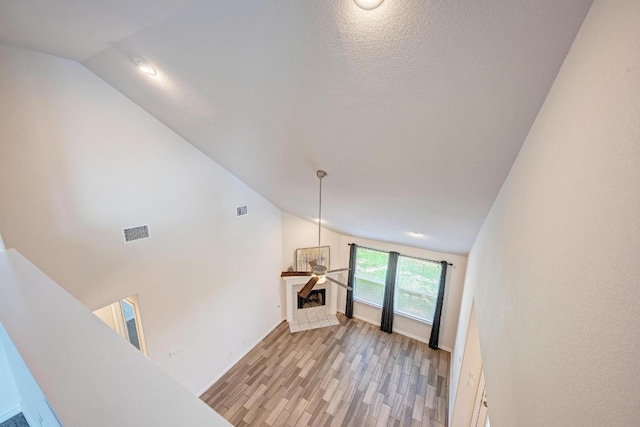 2953 Diego Dr, Round Rock, TX 78665 - unfurnished living room featuring lofted ceiling, a fireplace, and light wood-style flooring