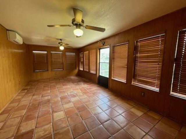 817 Mountain Creek Rd, Marble Falls, TX 78654 - empty room with wood walls, a ceiling fan, an AC wall unit, and light tile patterned flooring