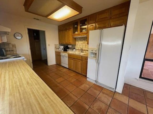 817 Mountain Creek Rd, Marble Falls, TX 78654 - kitchen featuring light countertops, white appliances, decorative backsplash, and brown cabinets