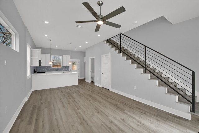 1104 Begonia Ter Unit 2, Austin, TX 78741 - unfurnished living room featuring stairs, ceiling fan, wood finished floors, and recessed lighting