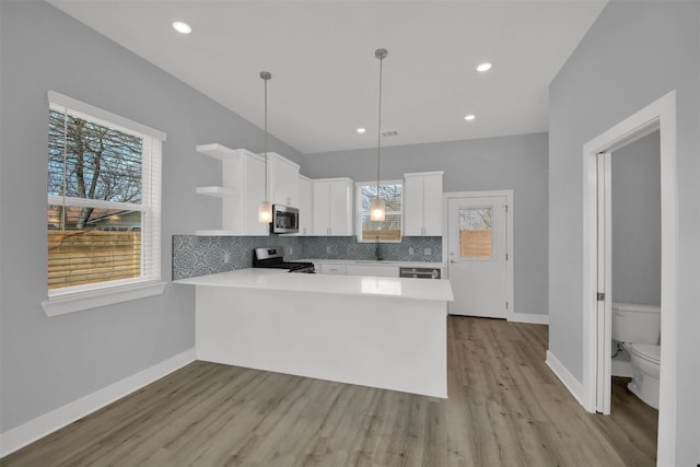 1104 Begonia Ter Unit 2, Austin, TX 78741 - kitchen with open shelves, white cabinets, a peninsula, light countertops, and light wood-style flooring