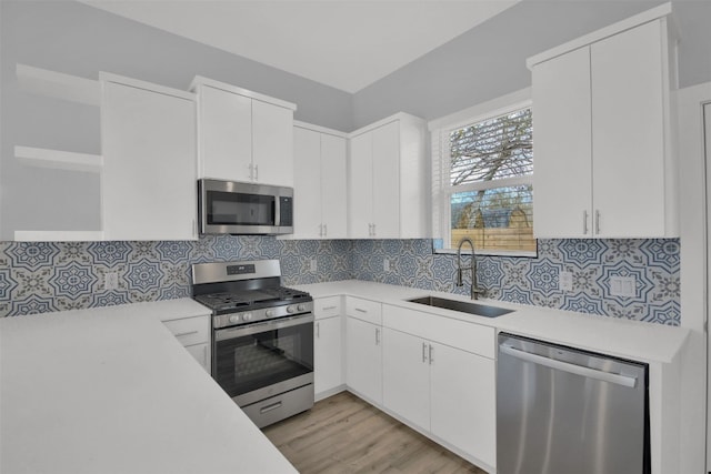 1104 Begonia Ter Unit 2, Austin, TX 78741 - kitchen featuring open shelves, appliances with stainless steel finishes, light countertops, white cabinets, and light wood finished floors