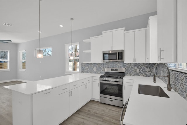 1104 Begonia Ter Unit 2, Austin, TX 78741 - kitchen with a peninsula, stainless steel appliances, tasteful backsplash, open shelves, and light countertops