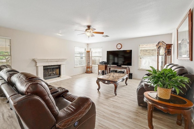 15433 Ozone Pl, Austin, TX 78728 - living area with ceiling fan, a fireplace, and light wood-style flooring