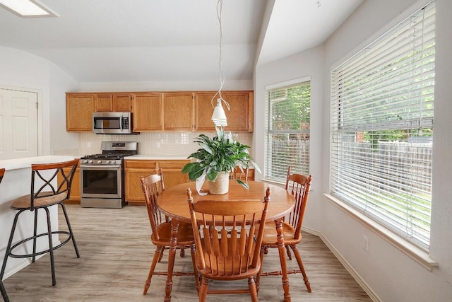 15433 Ozone Pl, Austin, TX 78728 - dining space with vaulted ceiling and light wood finished floors