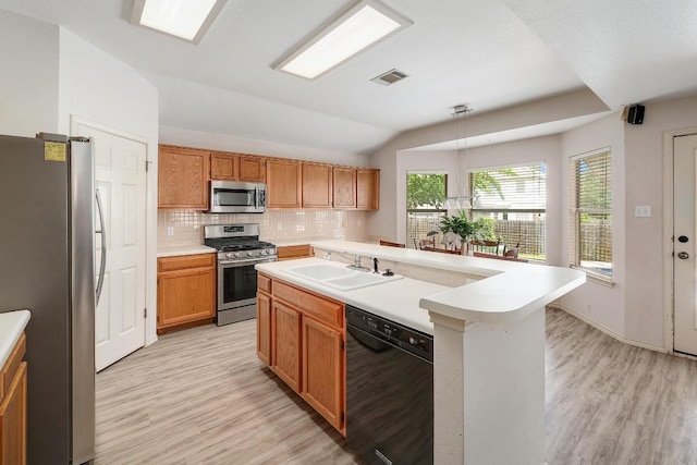 15433 Ozone Pl, Austin, TX 78728 - kitchen with appliances with stainless steel finishes, lofted ceiling, light wood-type flooring, decorative backsplash, and light countertops