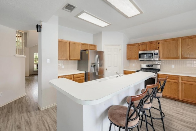 15433 Ozone Pl, Austin, TX 78728 - kitchen with lofted ceiling, light wood-type flooring, appliances with stainless steel finishes, and light countertops