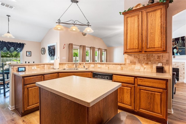 700 Stokesay Castle Path, Pflugerville, TX 78660 - kitchen featuring light wood-style floors, brown cabinetry, vaulted ceiling, light countertops, and a kitchen island