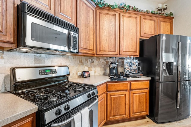 700 Stokesay Castle Path, Pflugerville, TX 78660 - kitchen featuring appliances with stainless steel finishes, brown cabinetry, backsplash, and light countertops