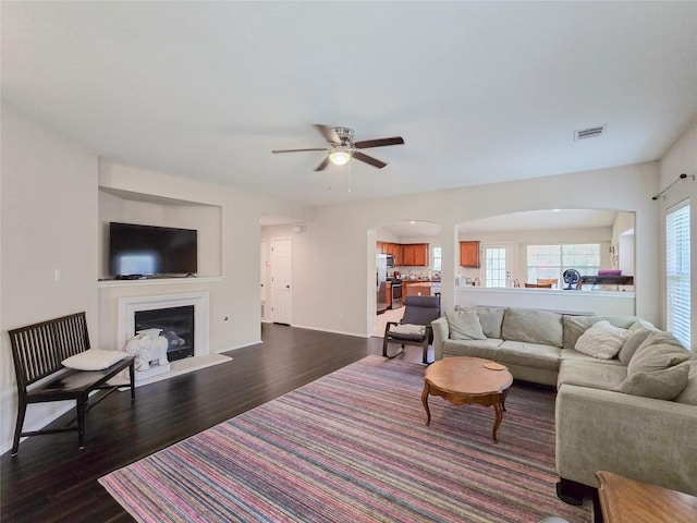 11704 Fletcher Hall Ln, Austin, TX 78717 - living room with dark wood-type flooring, ceiling fan, arched walkways, and a glass covered fireplace