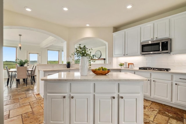 4700 River Place Blvd Unit 3, Austin, TX 78730 - kitchen featuring stone tile floors, arched walkways, tasteful backsplash, a kitchen island, and recessed lighting