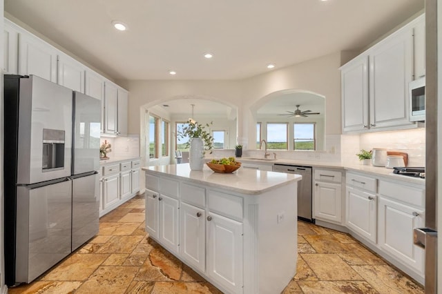 4700 River Place Blvd Unit 3, Austin, TX 78730 - kitchen featuring stone tile floors, stainless steel appliances, a kitchen island, white cabinets, and recessed lighting
