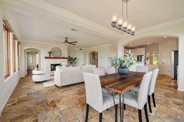 4700 River Place Blvd Unit 3, Austin, TX 78730 - dining room featuring stone tile flooring, ceiling fan, a stone fireplace, crown molding, and arched walkways
