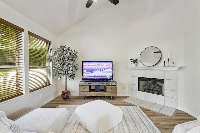 12600 Grimes Ranch Ct, Austin, TX 78732 - living area with a tiled fireplace, ceiling fan, wood finished floors, and high vaulted ceiling