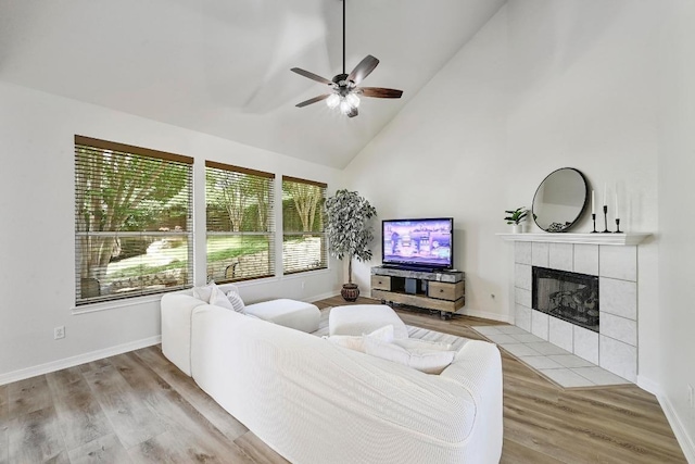 12600 Grimes Ranch Ct, Austin, TX 78732 - living room with plenty of natural light, a ceiling fan, a tiled fireplace, light wood-style flooring, and high vaulted ceiling