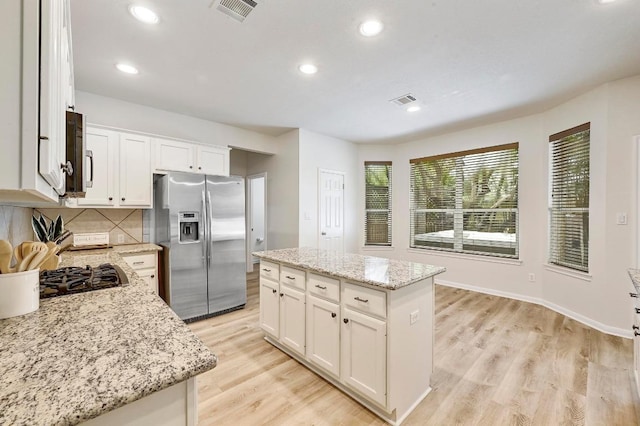 12600 Grimes Ranch Ct, Austin, TX 78732 - kitchen featuring stainless steel fridge with ice dispenser, backsplash, white cabinets, light wood-style flooring, and a kitchen island