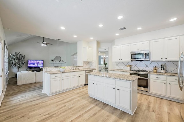 12600 Grimes Ranch Ct, Austin, TX 78732 - kitchen featuring a peninsula, ceiling fan, white cabinets, open floor plan, and tasteful backsplash