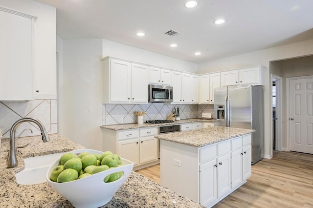 12600 Grimes Ranch Ct, Austin, TX 78732 - kitchen with appliances with stainless steel finishes, backsplash, white cabinetry, and recessed lighting