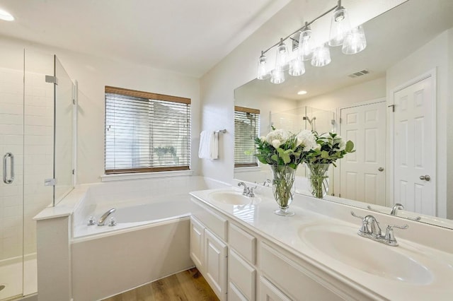 12600 Grimes Ranch Ct, Austin, TX 78732 - bathroom featuring a stall shower, a bath, double vanity, and wood finished floors