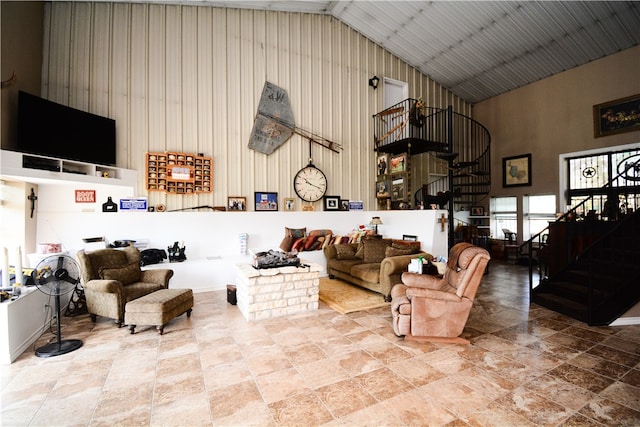 living room with wooden walls and high vaulted ceiling