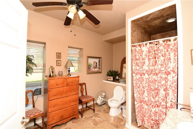 bathroom featuring walk in shower, vanity, toilet, and ceiling fan