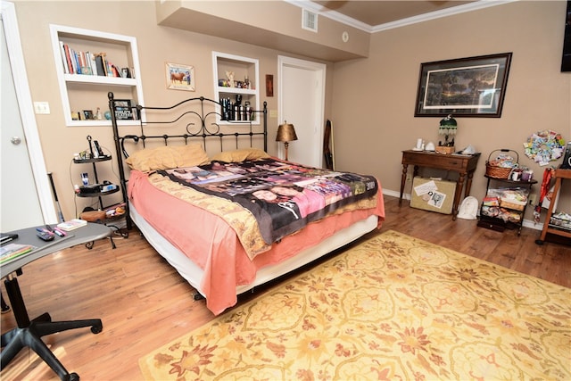 bedroom featuring hardwood / wood-style flooring and crown molding